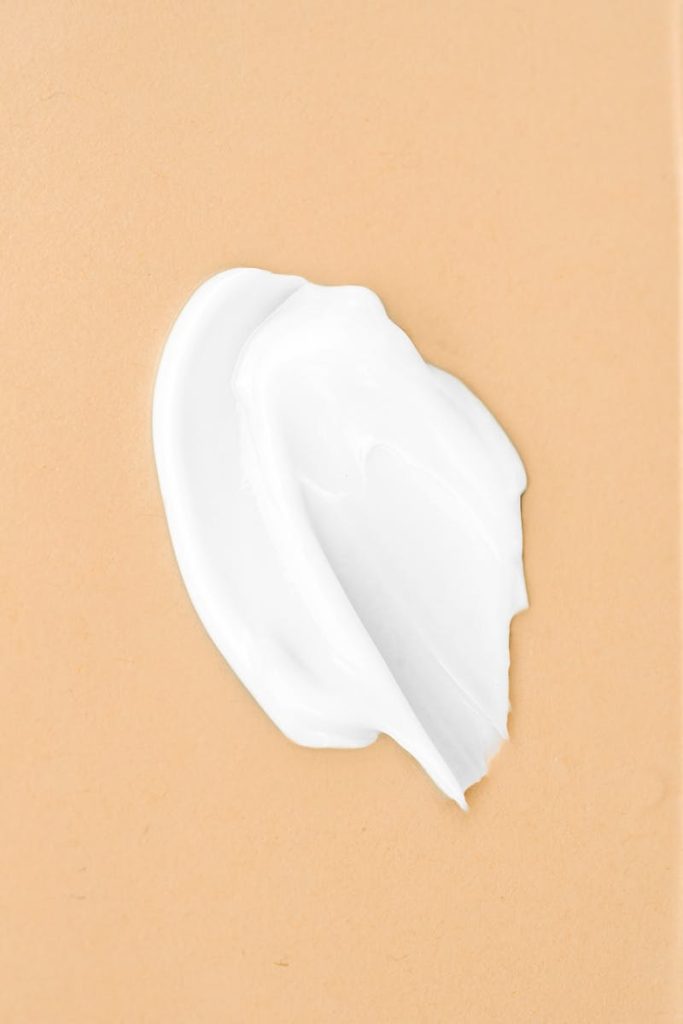 Smooth white cream on beige background, perfect for skincare product design.