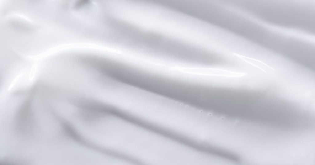 A detailed close-up of a smooth white cream texture, perfect for backgrounds or food imagery.