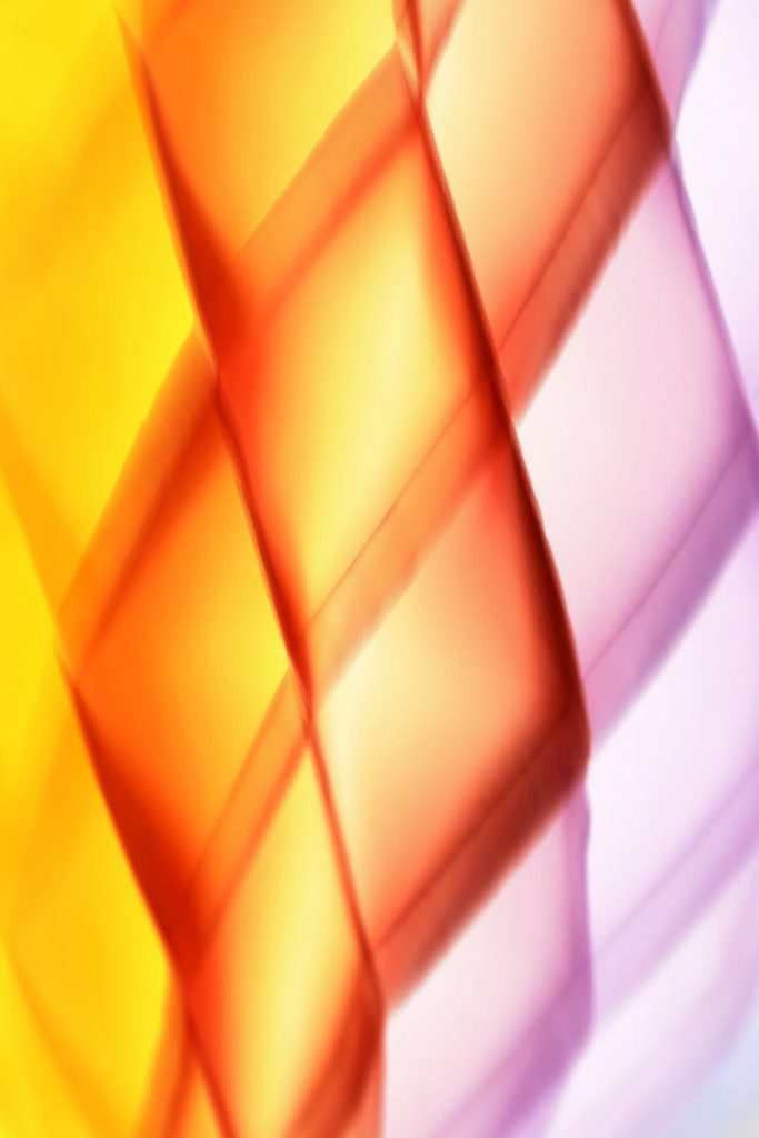 Vivid abstract image featuring a colorful light pattern with yellow, orange, and pink tones.