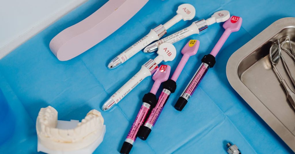 A detailed view of dental instruments and materials arranged on a sterile blue surface in a clinical setting.