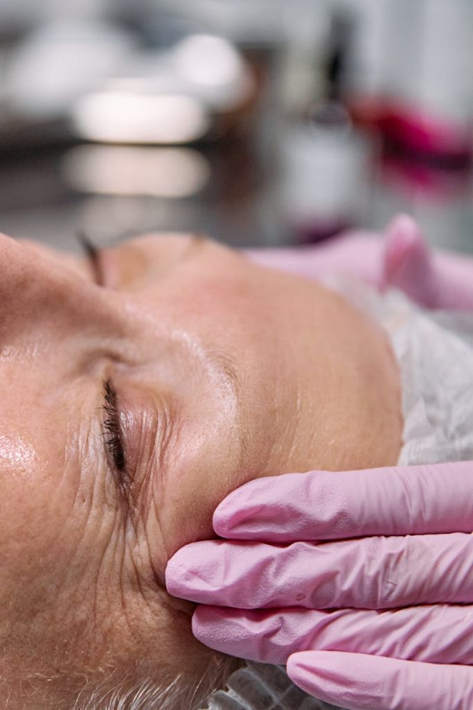 Close-up of a senior woman receiving a relaxing facial treatment in a spa setting.
