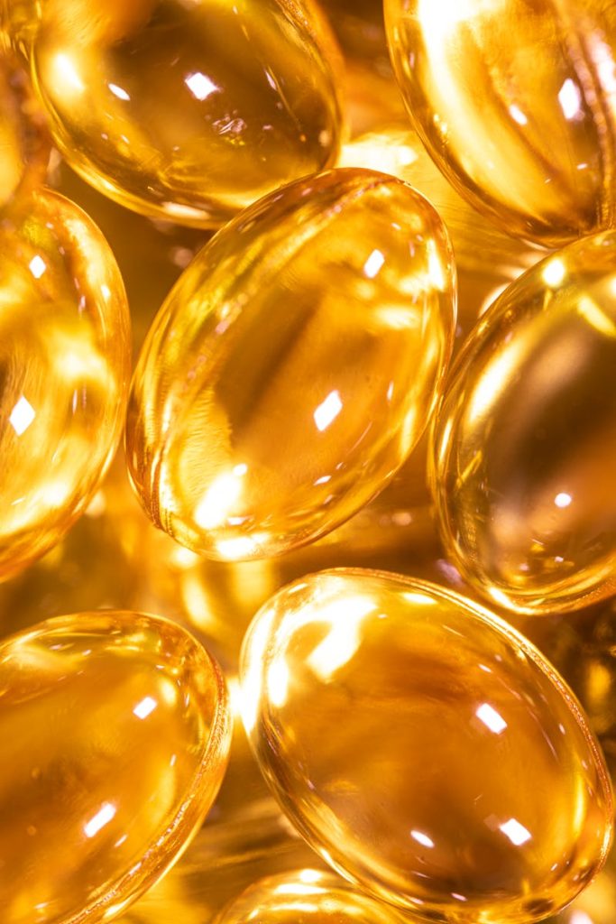 Bright close-up image of golden gel capsules, ideal for health and wellness themes.